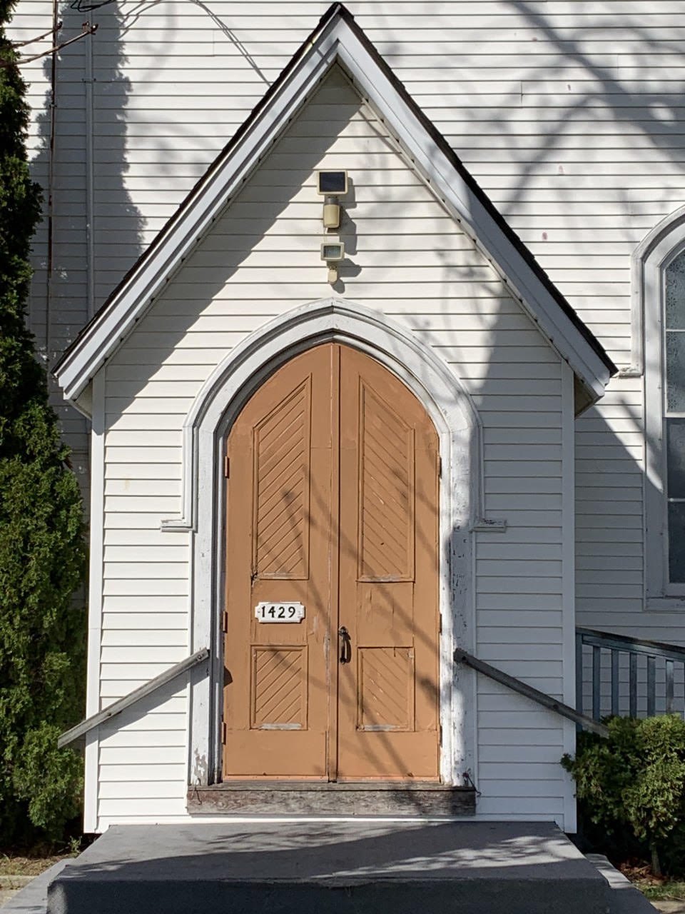 The arched wooden front doors of the church at 1429 Third Avenue Louth
